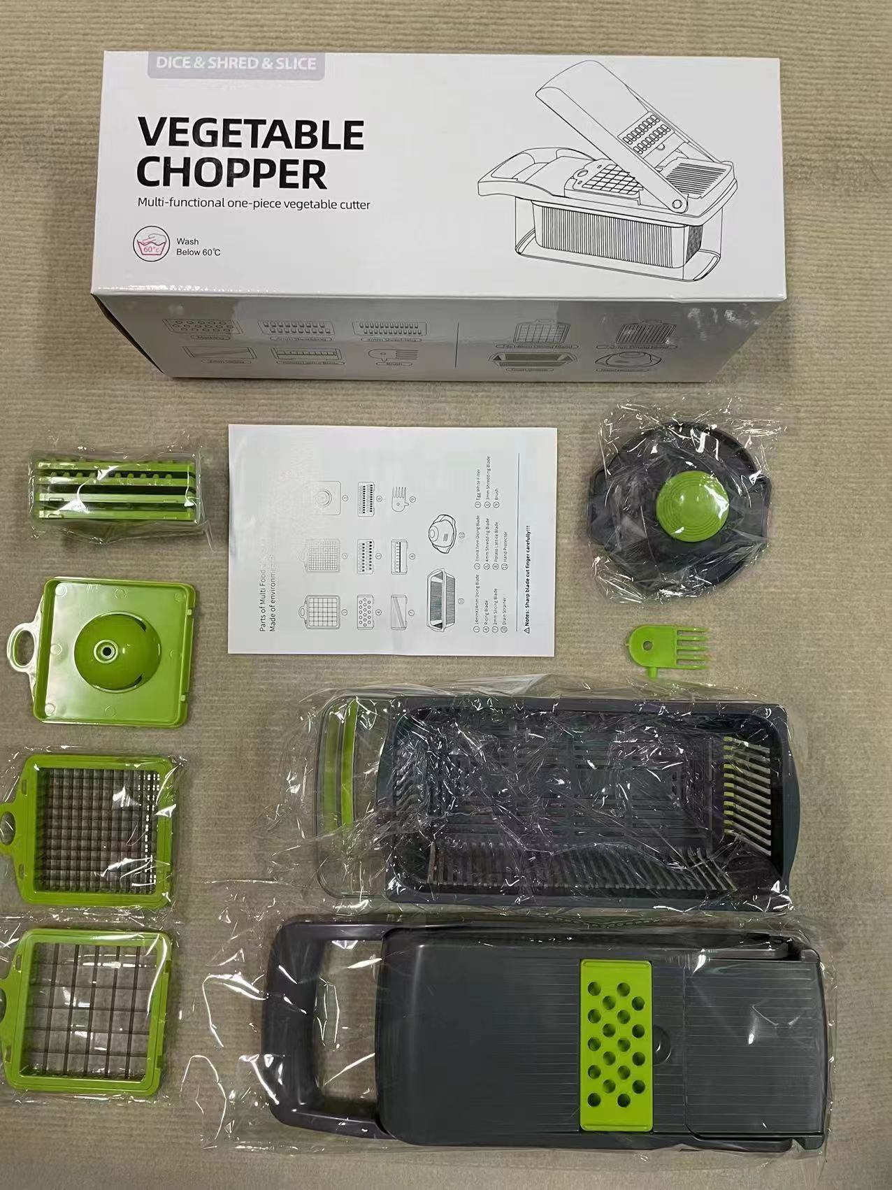 Gray and green vegetable and fruit chopper/slicer with 12 different attachments