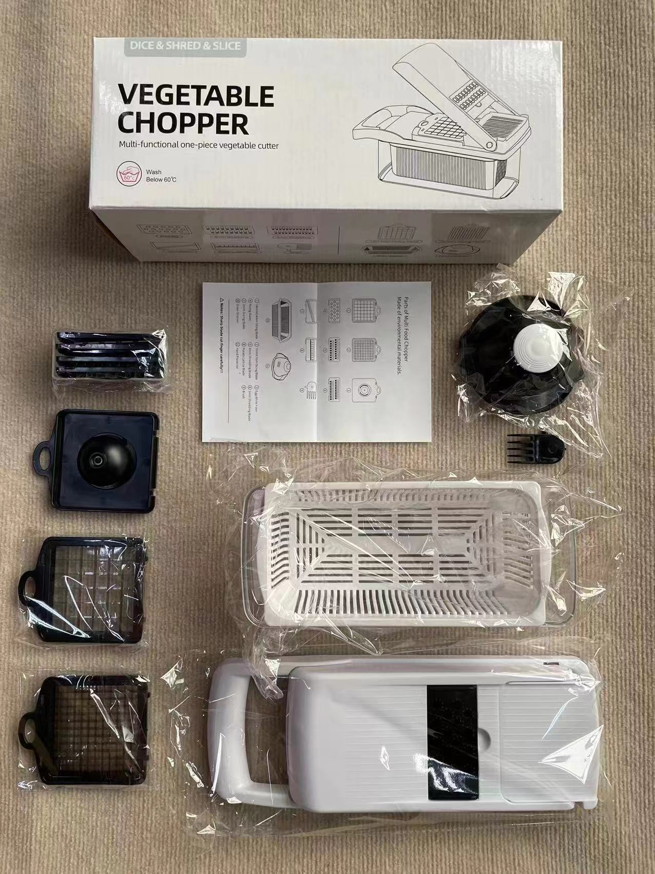 Black and white vegetable and fruit chopper/slicer with 12 different attachments